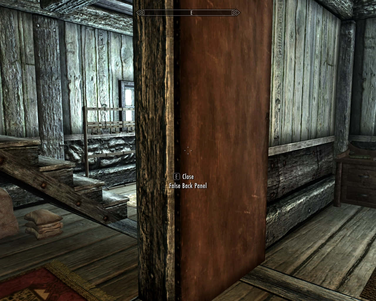 Skyrim Solitude 桌布 壁紙 — 質樸的木屋內部，有風化的木板樓梯和關閉的門，顯示遊戲UI文字。