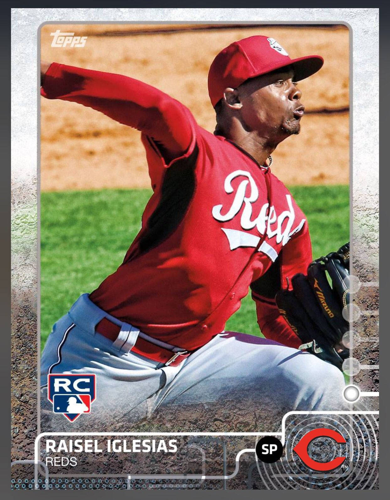 棒球投手 Raisel Iglesias 身穿 Reds 球衣，在陽光明媚的場地上投球。