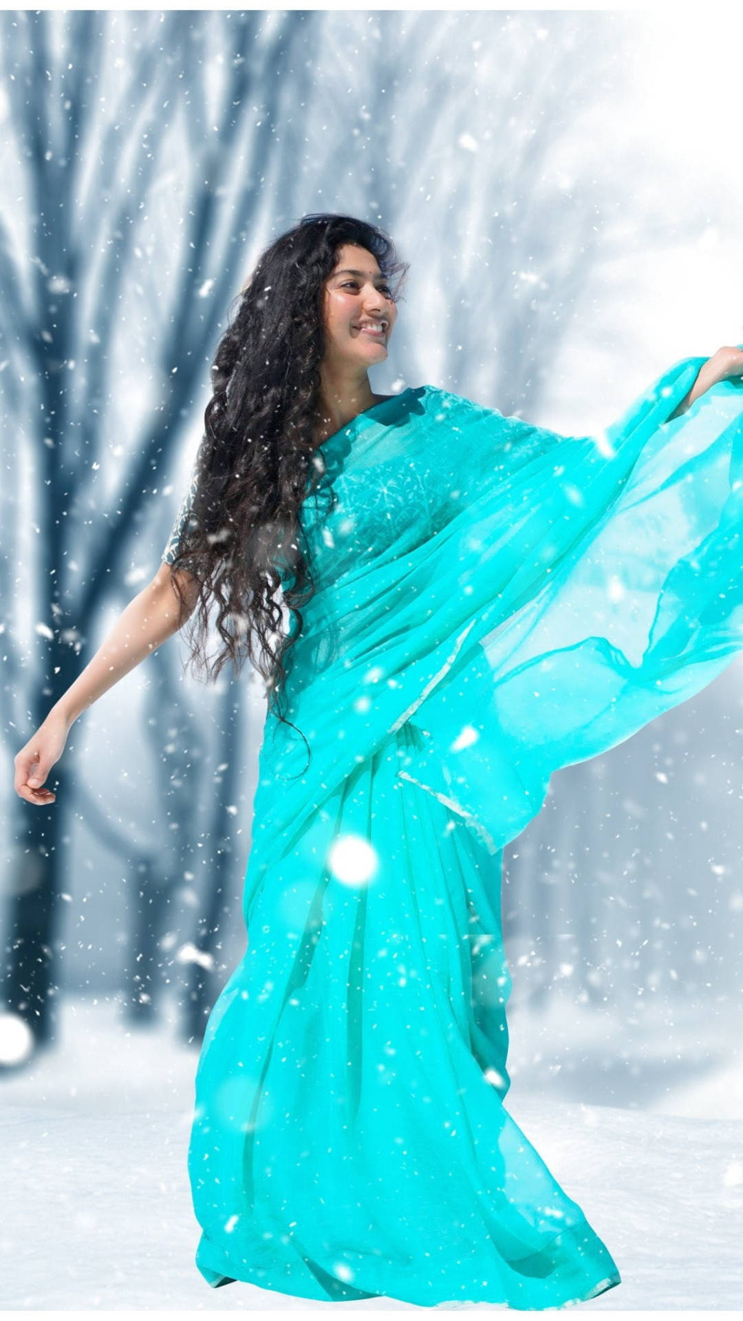 穿綠松石色連衣裙的女人在雪地森林中跳舞