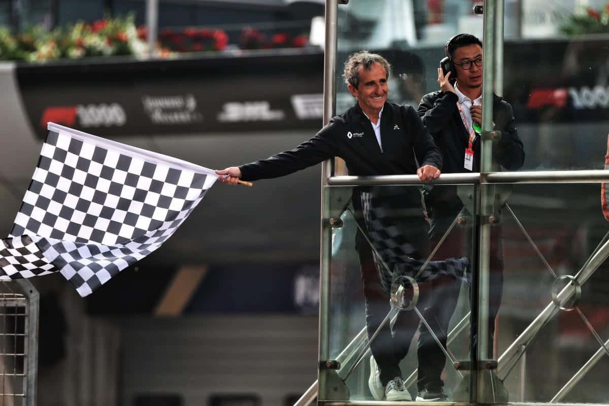Chequered Flag 桌布 壁紙 — 賽事工作人員在明亮的日光下，於賽車活動中從玻璃露台揮動格仔旗。