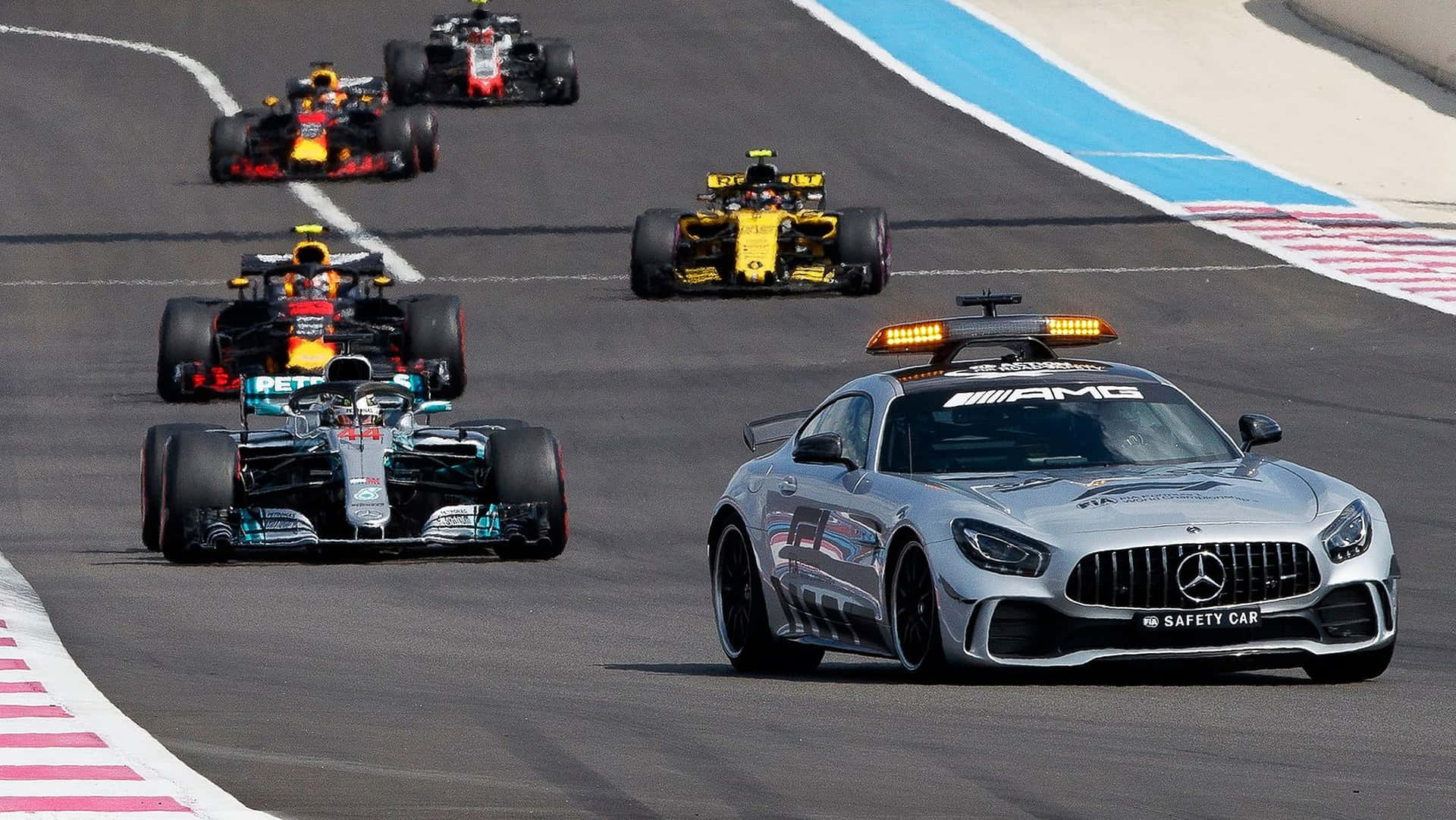 銀色 Mercedes-AMG 安全車帶領 Formula 1 賽車在賽道上行駛。