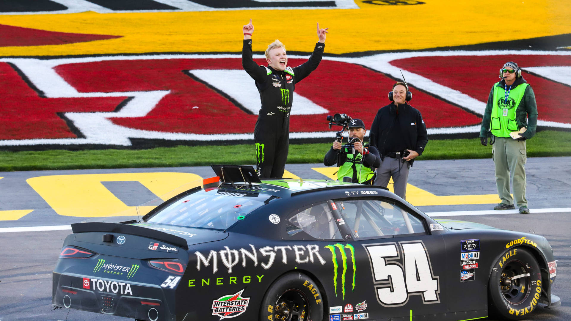 NASCAR車手在賽道上於其賽車上慶祝勝利。