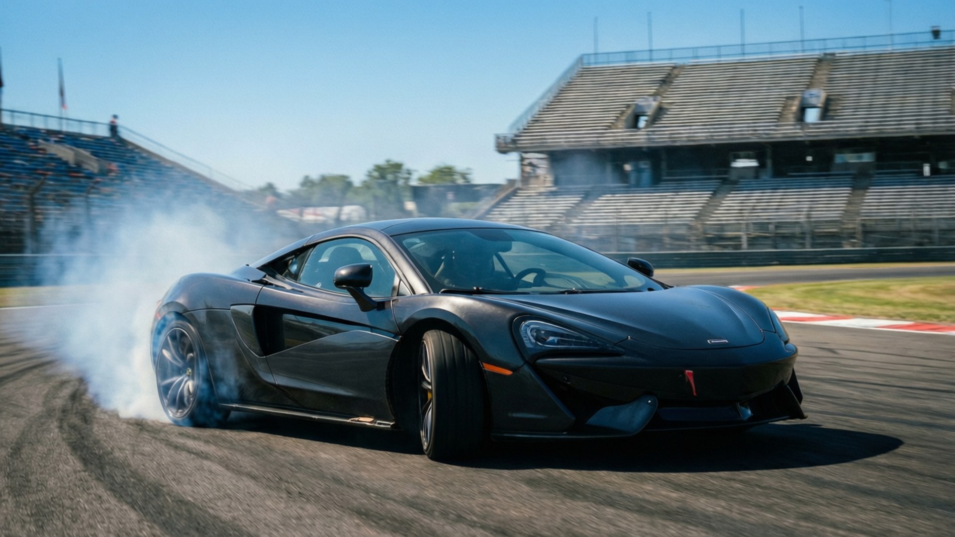 黑色McLaren跑車在賽道上飄移冒煙