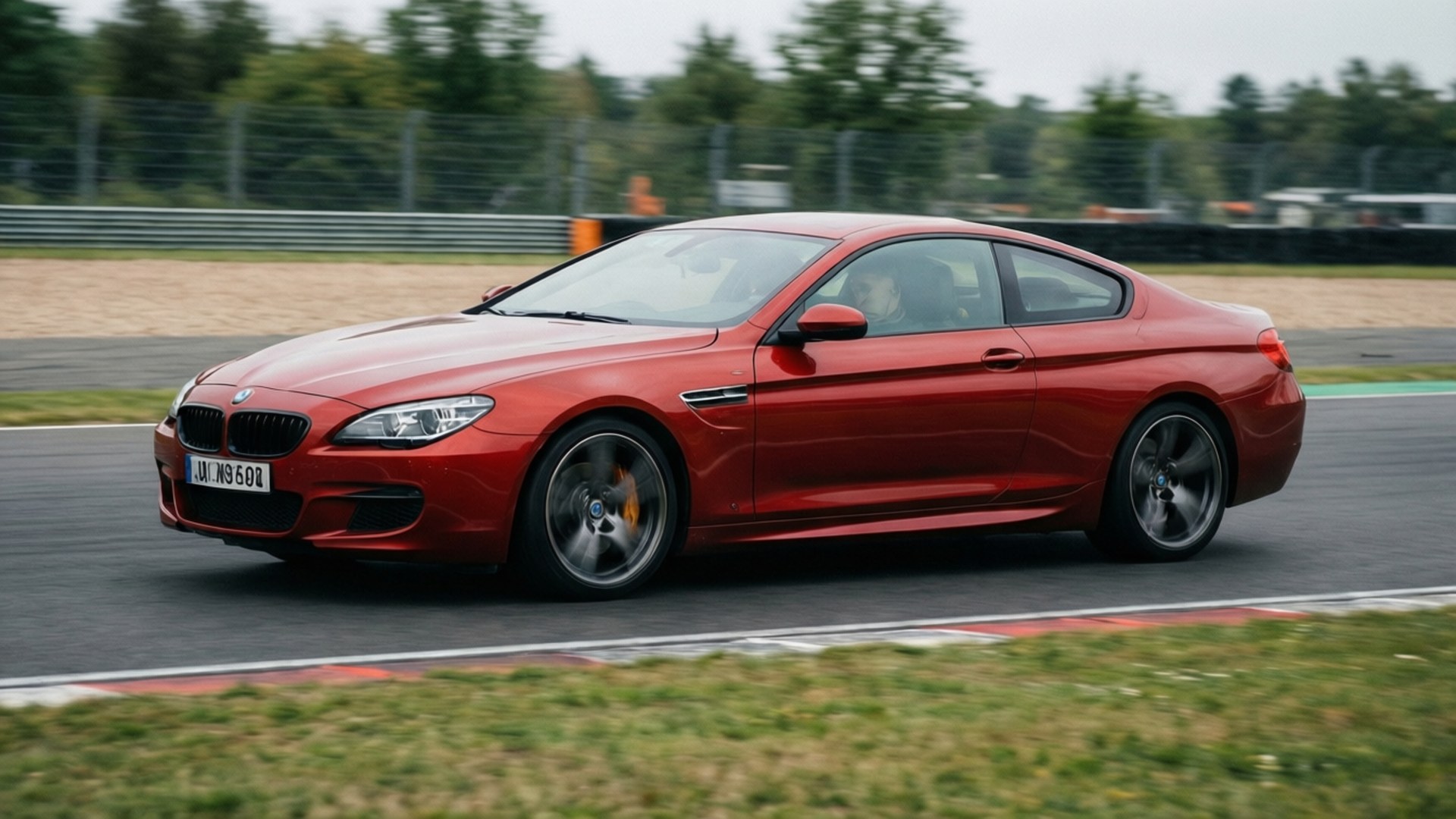 紅色BMW M6雙門跑車在賽道上疾馳，背景模糊。