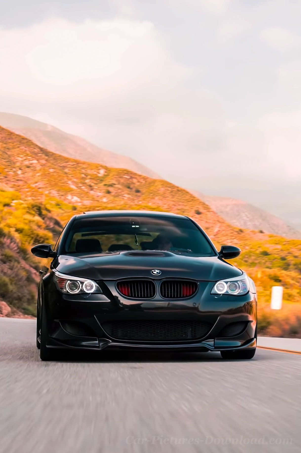黑色BMW M3在夕陽下的山路疾馳