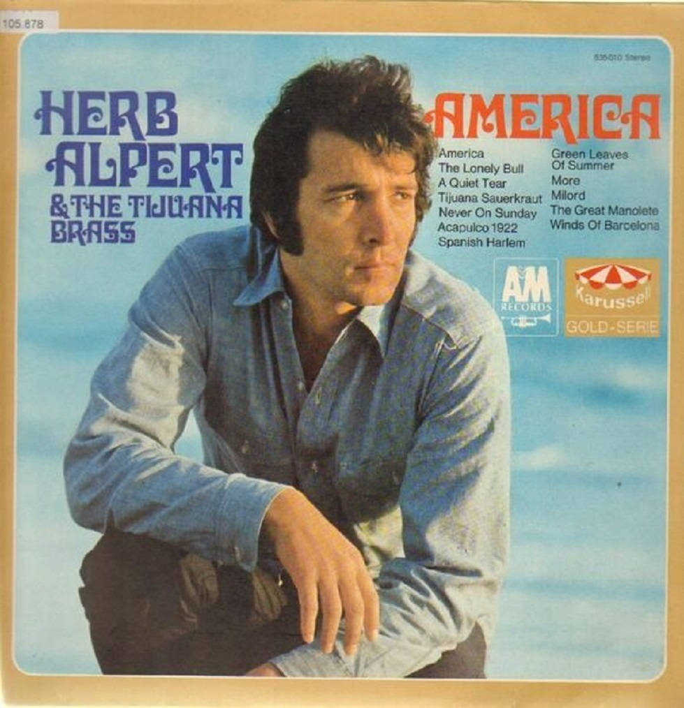赫布·阿爾珀特與蒂華納銅管樂隊《America》專輯 壁紙 — Herb Alpert 身穿藍色襯衫，在America的復古專輯封面上以柔和的藍天為背景擺姿勢。