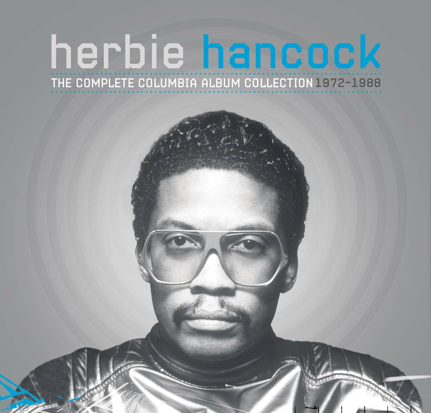 Herbie Hancock 的黑白肖像，戴著大眼鏡和閃亮外套。