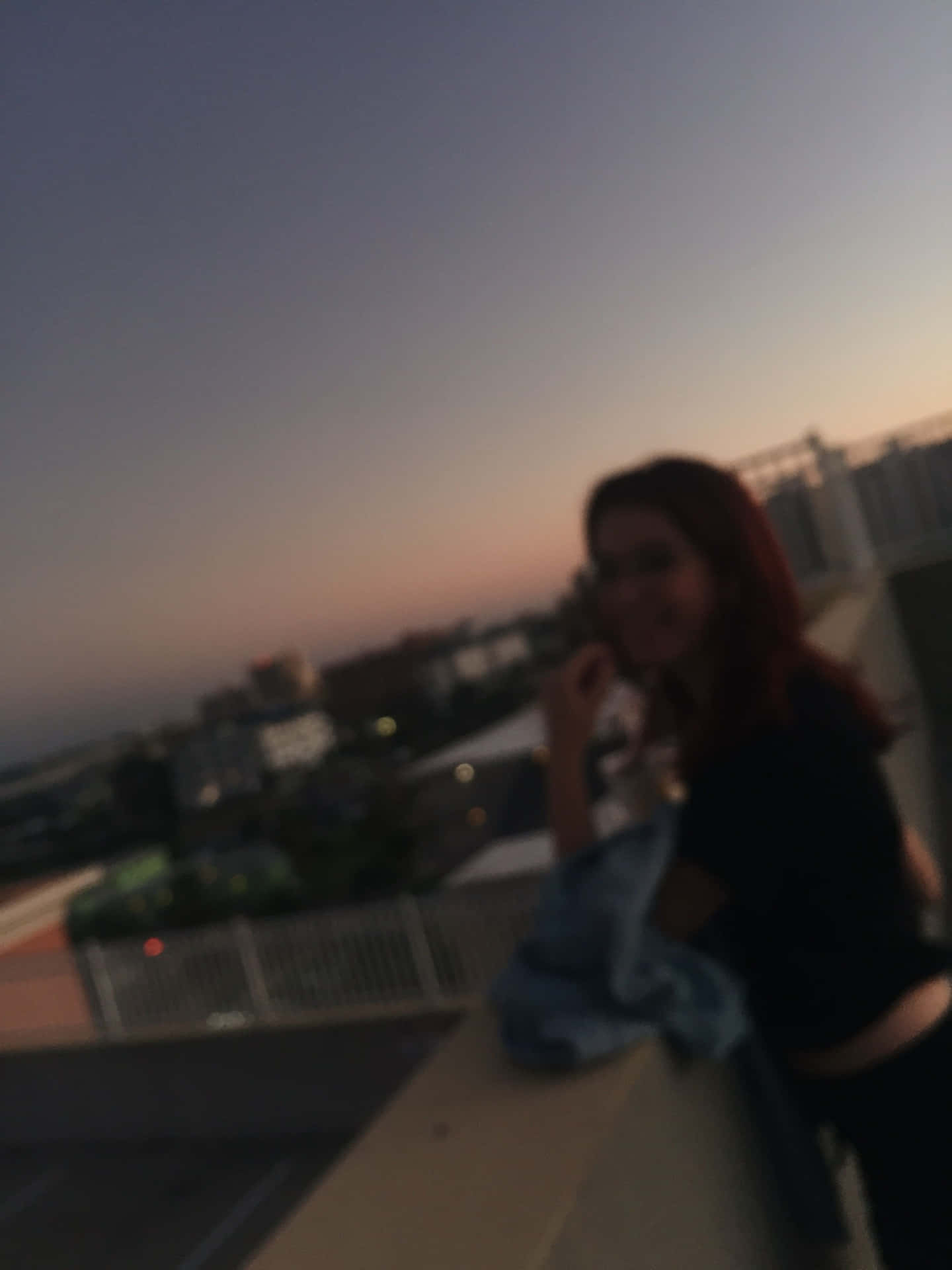 黃昏時分在屋頂上微笑的女性，背景有城市燈光。