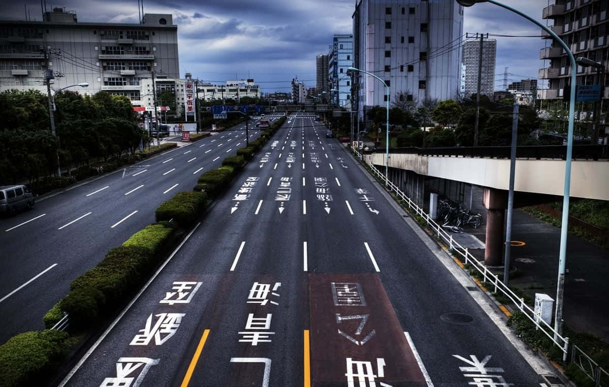 多雲天空下，帶有日本道路標記的空蕩城市高速公路。