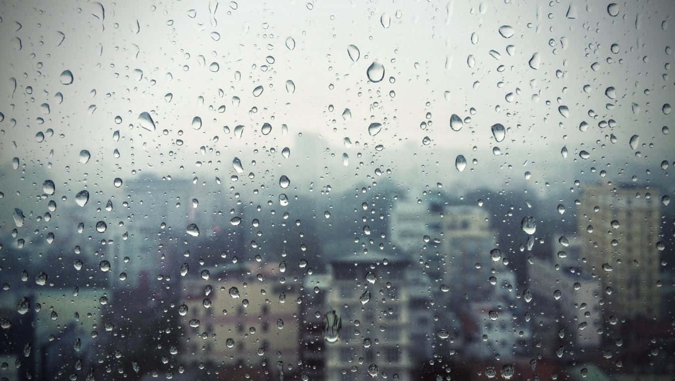 窗玻璃上的雨滴，背後是模糊的城市景觀。
