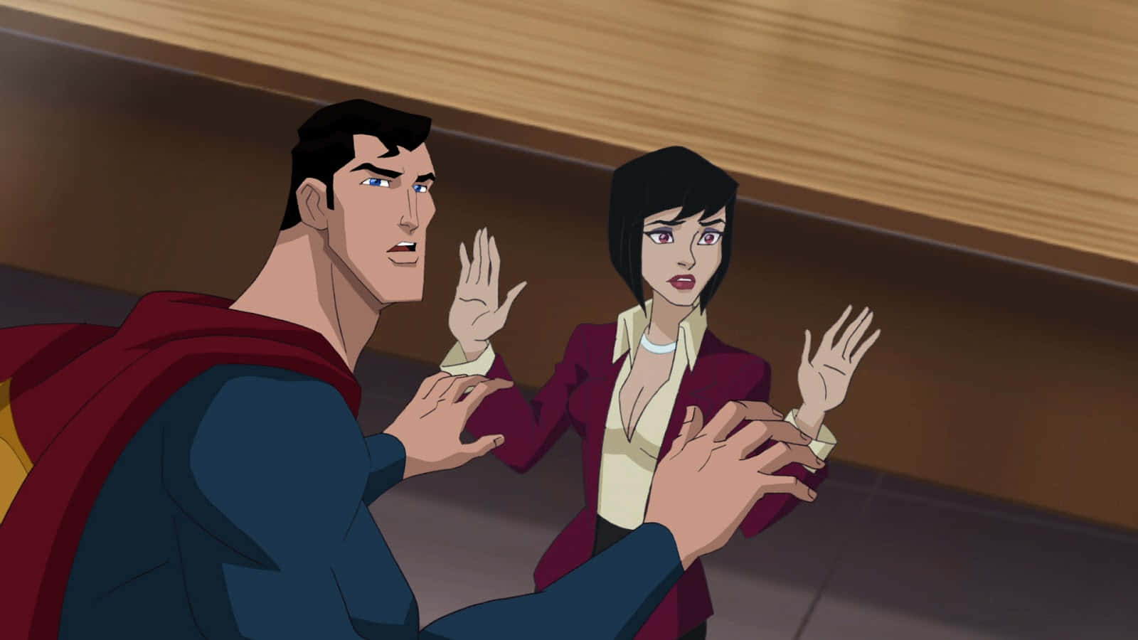 Superman Unbound 桌布 壁紙 — 超人同一個著住棗紅色西裝外套嘅女人喺一個光線昏暗、天花板有木質面板嘅走廊入面急切咁做手勢。