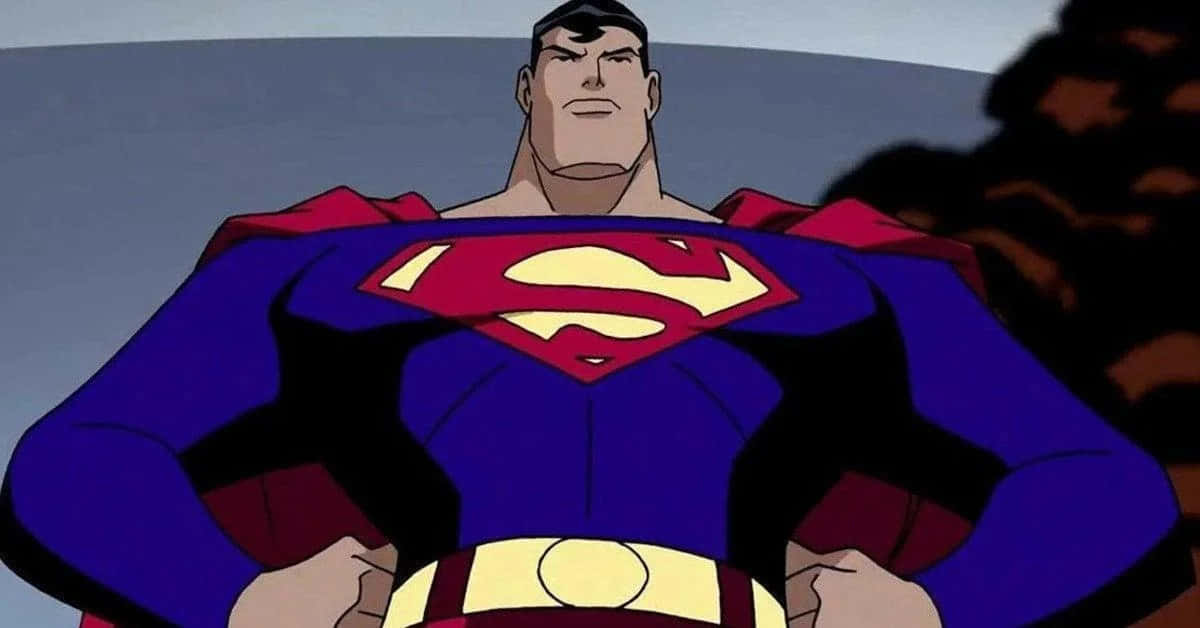 Superman The Animated Series 桌布 壁紙 — 超人自信地站立，身穿標誌性的藍色套裝，配以紅色斗篷和黃色「S」盾牌，背景是柔和天空。
