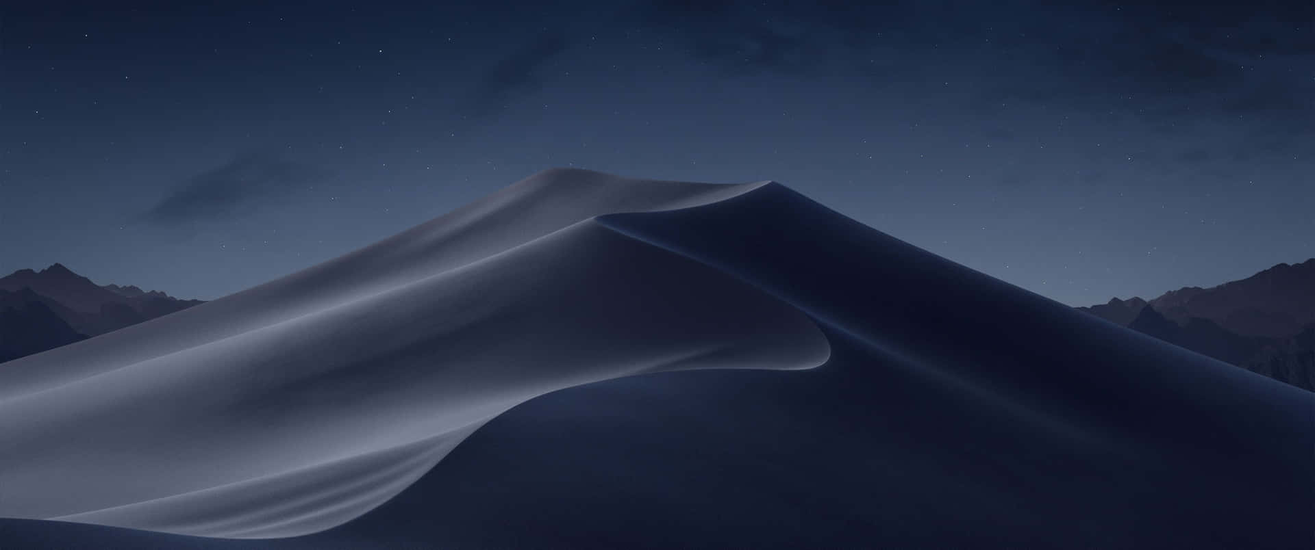 繁星夜空下平滑的沙漠沙丘與山巒剪影