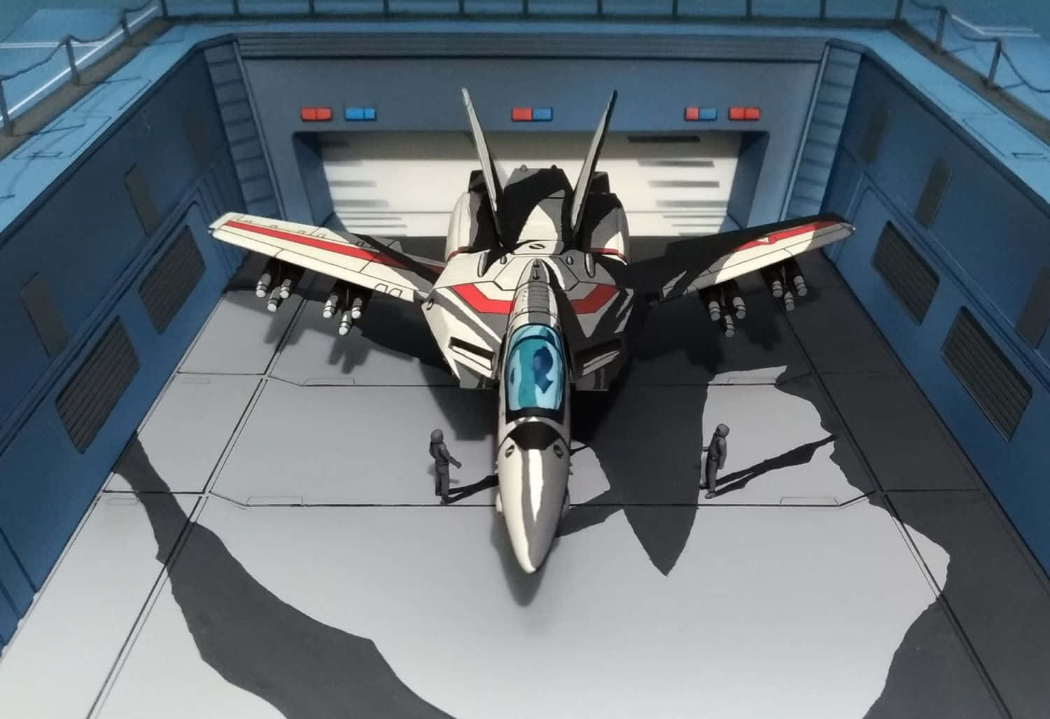 《超時空要塞》中人機合體的強大力量 壁紙 — 一架流線型的白色和紅色戰鬥機停在一個高科技機庫中，兩個小人影在明亮的人造光下檢查它。
