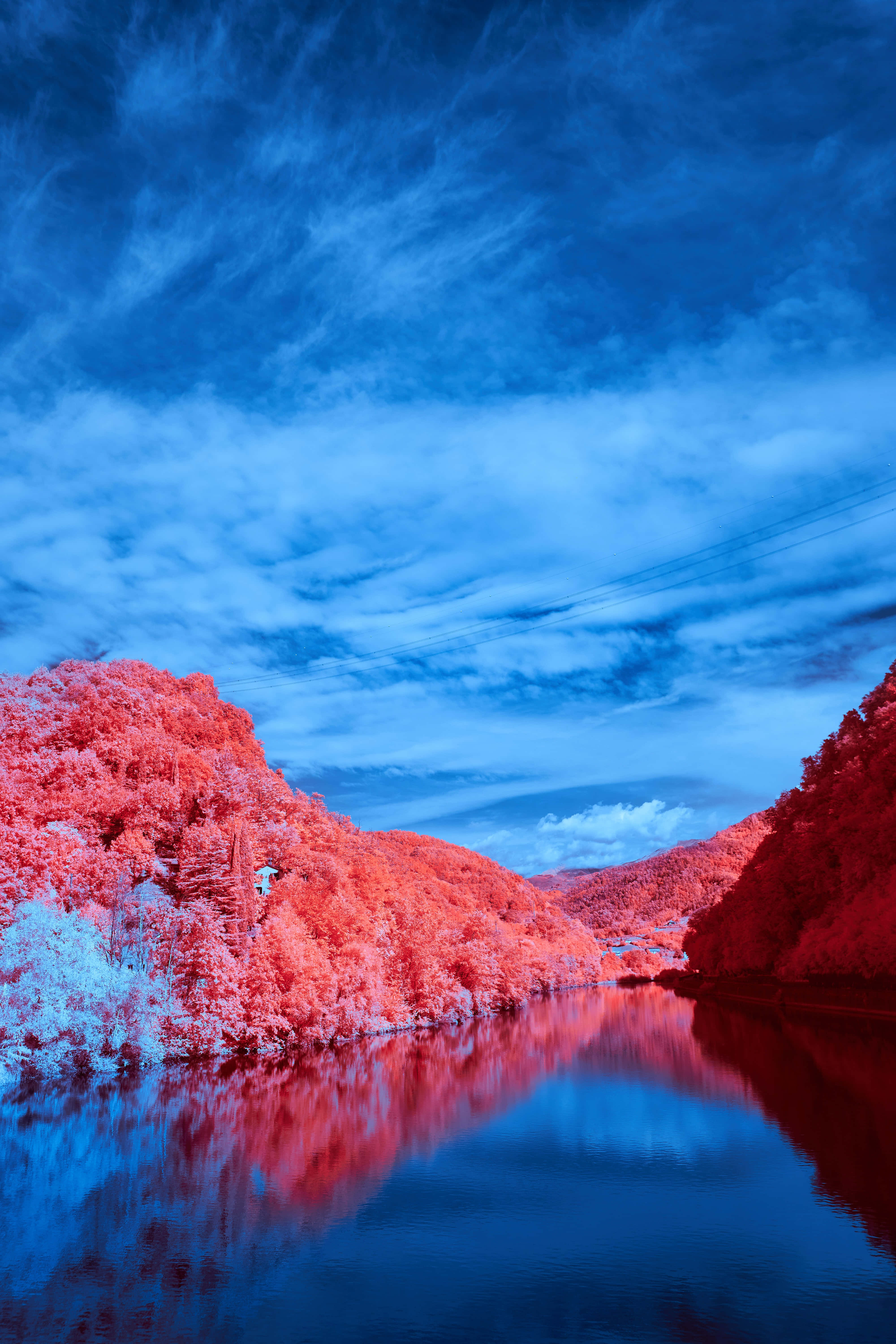 Nature Scenery 桌布 壁紙 — 超現實的紅外線風景，平靜的河流兩旁是鮮紅色的樹木，上方是深藍色的天空和縷縷薄雲。