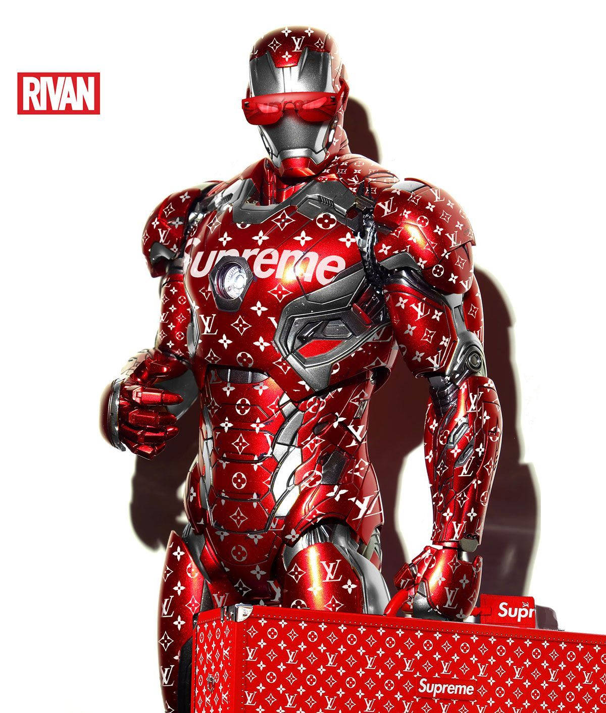 超級英雄 Supreme 鐵人裝甲 壁紙 — 一件帶有光澤的紅色鐵甲奇俠戰衣，上面覆蓋著 Louis Vuitton 字母圖案和 Supreme 標誌，矗立在純白色背景前。