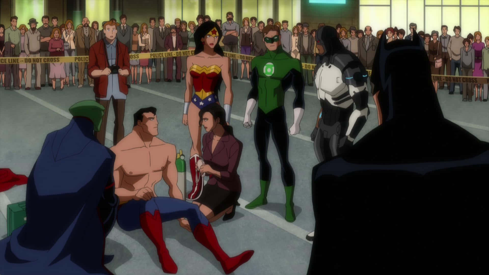 Justice League Doom 桌布 壁紙 — 超級英雄聚集在受傷的超人周圍，人群在警察封鎖線後觀看，場景在簡樸的室內環境中。