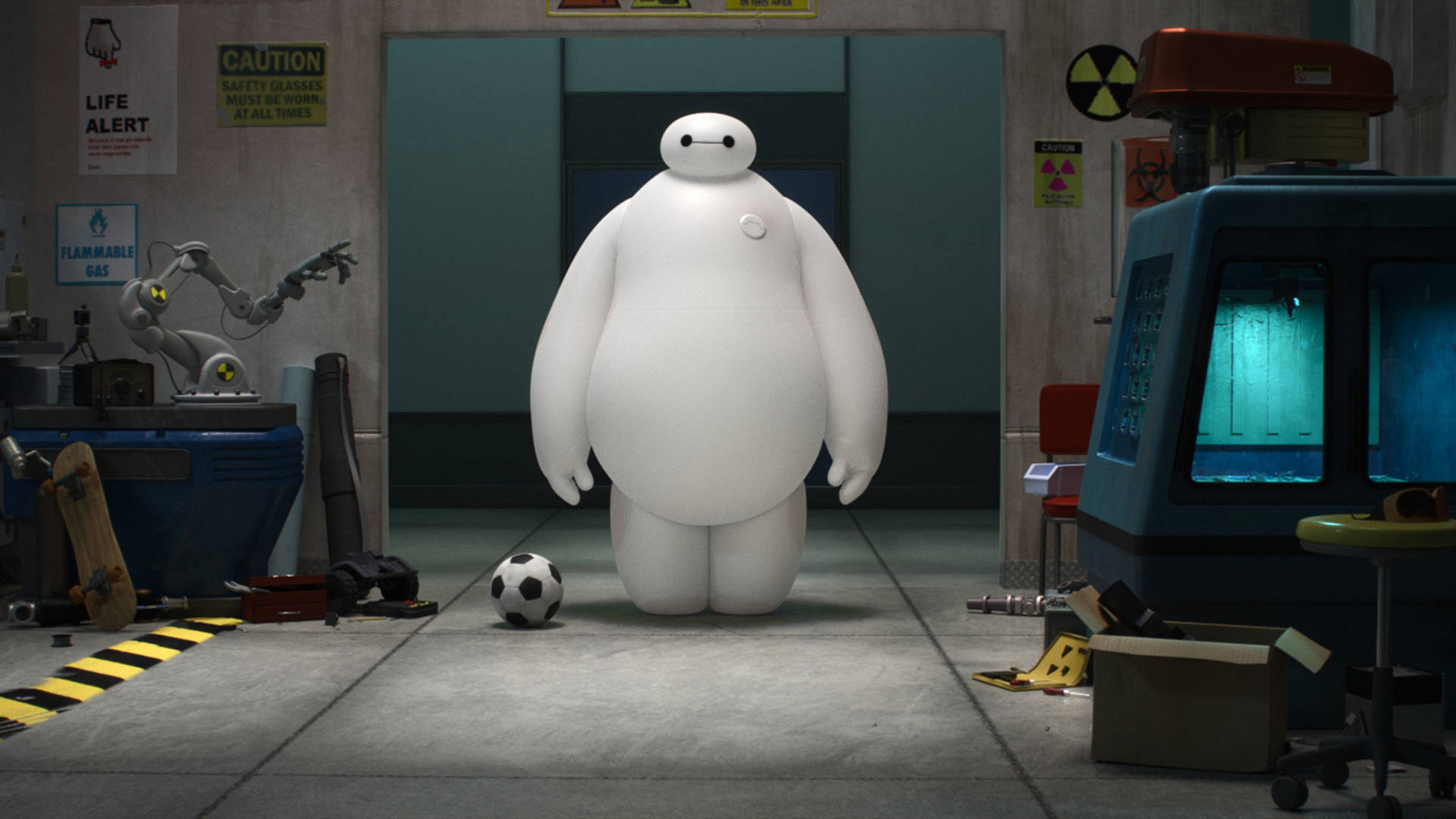 超能陸戰隊 Baymax 足球 壁紙 — 一個大型白色充氣機械人站在雜亂的實驗室中，腳邊有一個足球，牆上有警告標誌。