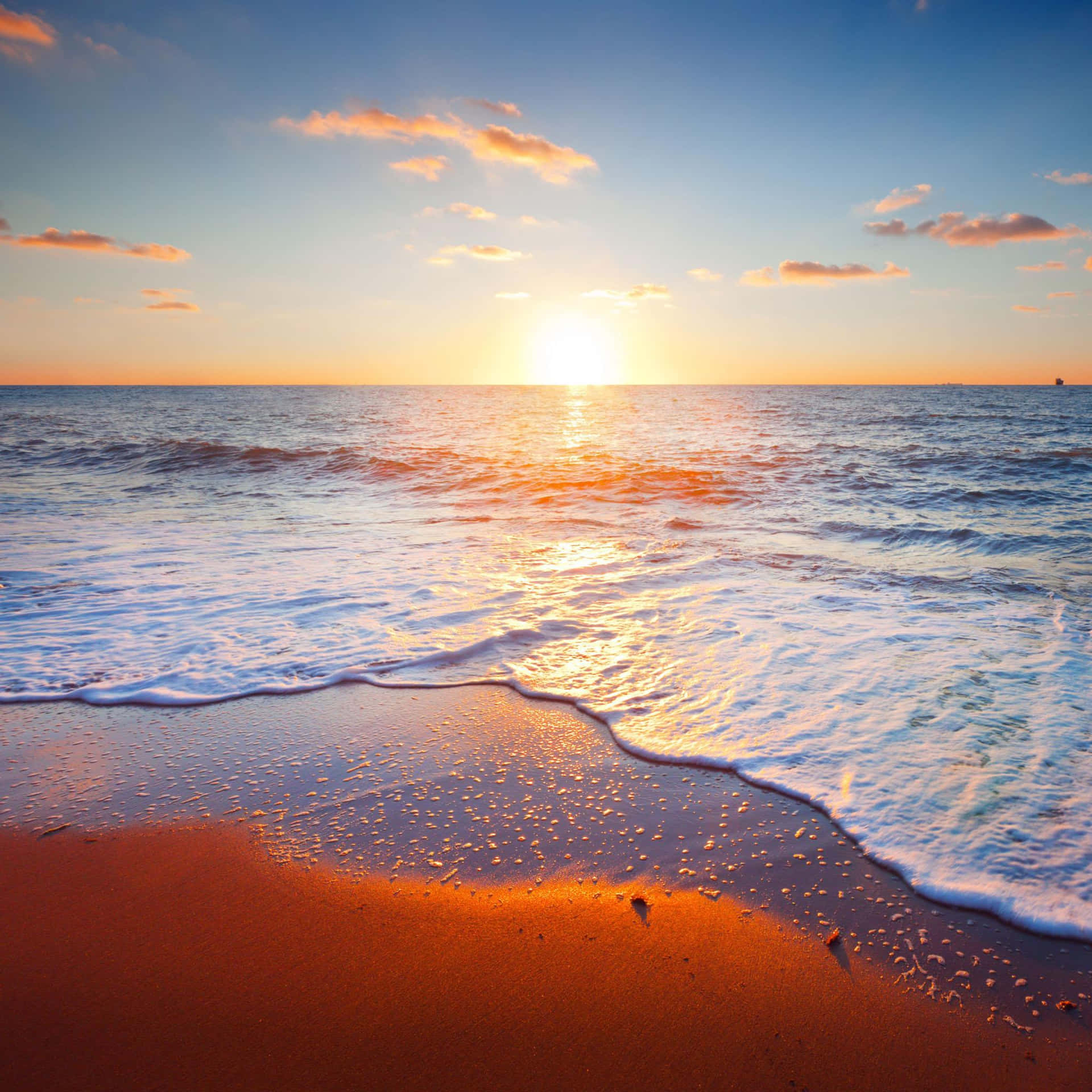 夕陽下的海洋，海浪拍打沙灘