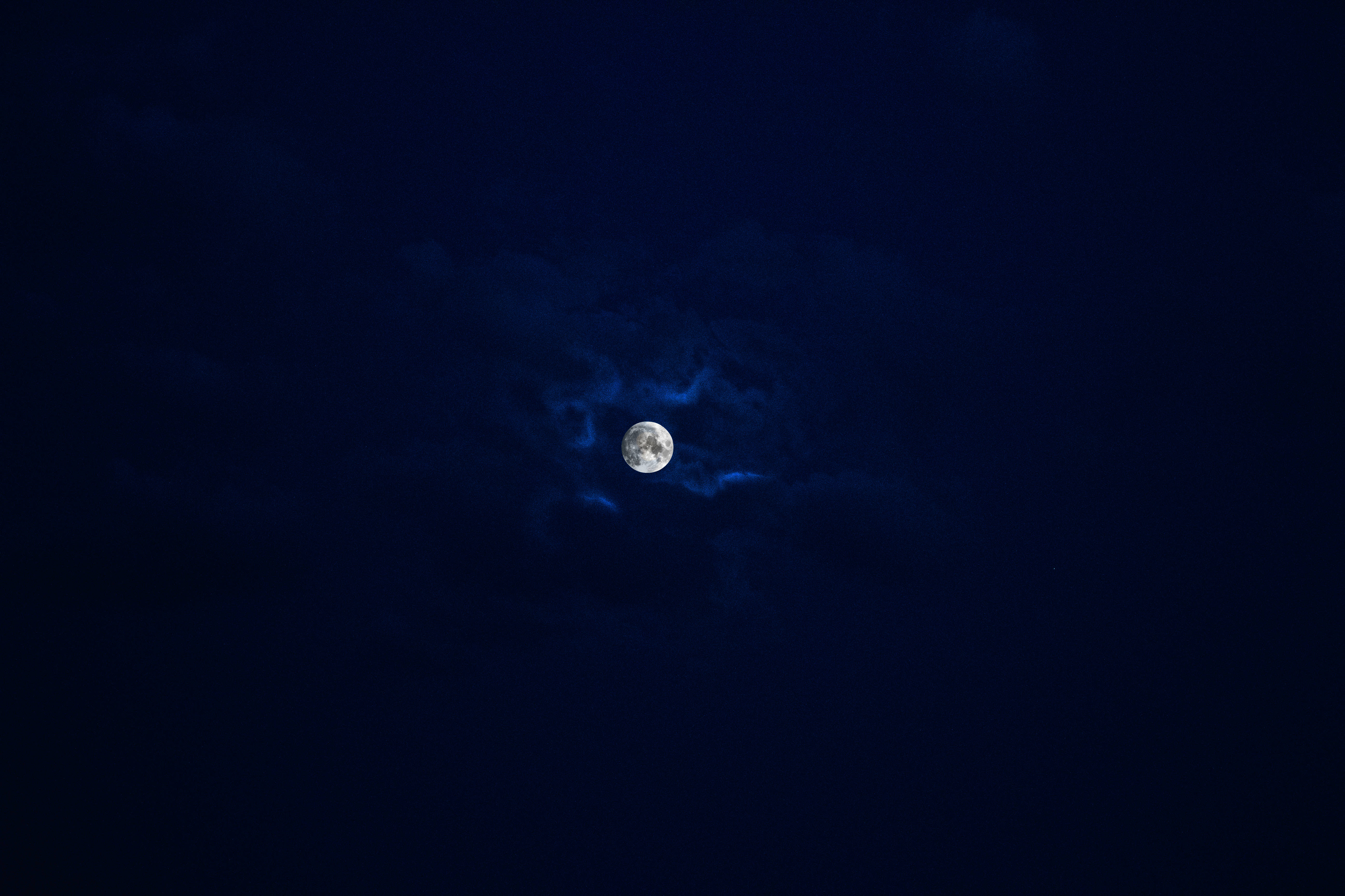 超酷的滿月 壁紙 — 一輪明亮的滿月透過縷縷雲彩，在深靛藍色的夜空中閃耀。