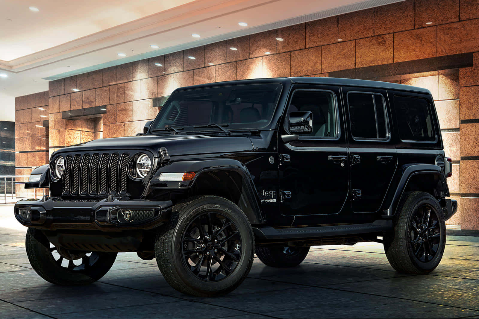越野就緒：堅韌精緻的Jeep Wrangler 壁紙 — 一架時尚的黑色Jeep Wrangler在現代室內大堂中格外醒目，地板拋光，石牆溫暖。