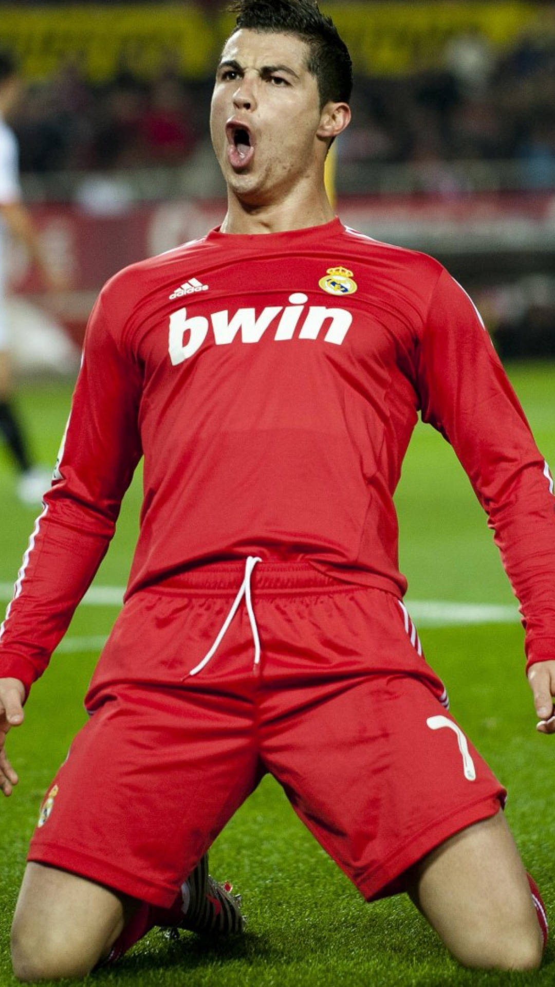 Ronaldo 桌布 壁紙 — 足球員基斯坦奴·朗拿度在草地上跪著，身穿紅色球衣，比賽中張開嘴巴發出勝利的呼喊。