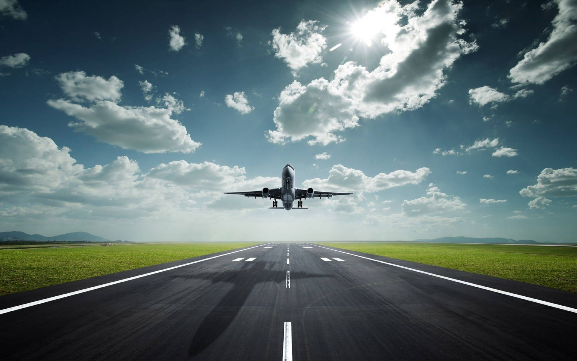 一架飛機在陽光明媚、有雲的天空下從跑道起飛。