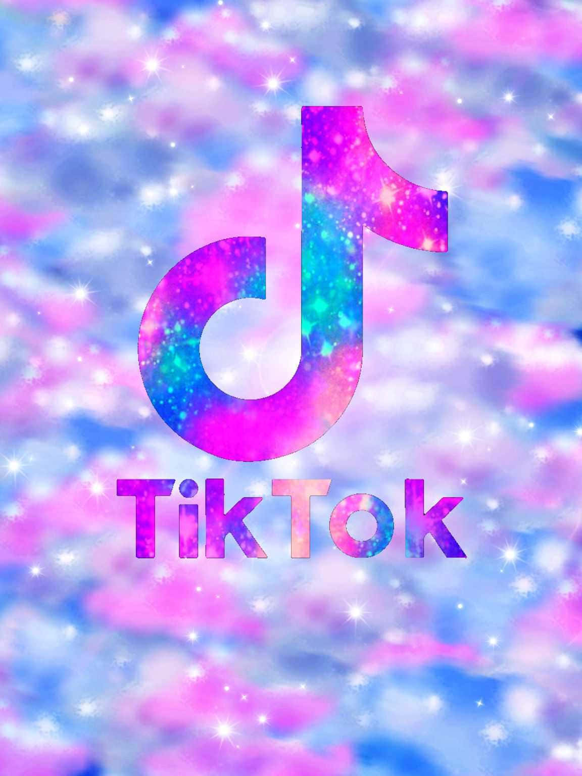 跟上潮流，讓TikTok為你實現夢想 壁紙 — TikTok 標誌在夢幻宇宙背景下閃爍著粉紅色和藍色的閃光。