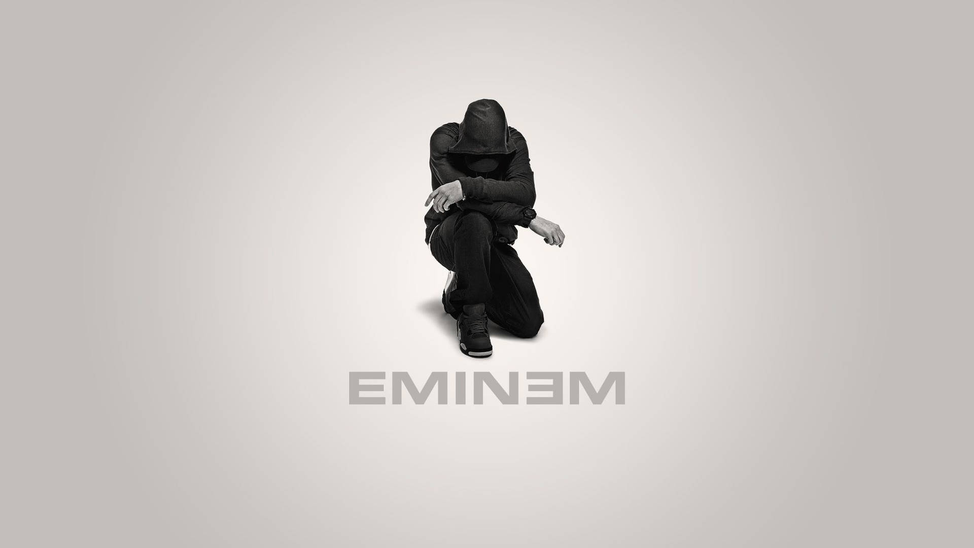 一個戴帽子的人蹲著，下方有文字「EMINEM」。