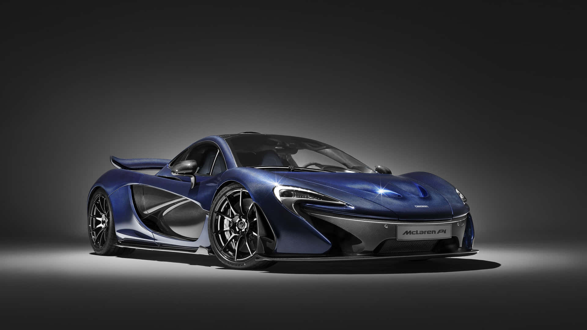 藍色McLaren P1超級跑車在攝影棚燈光下，背景深色。