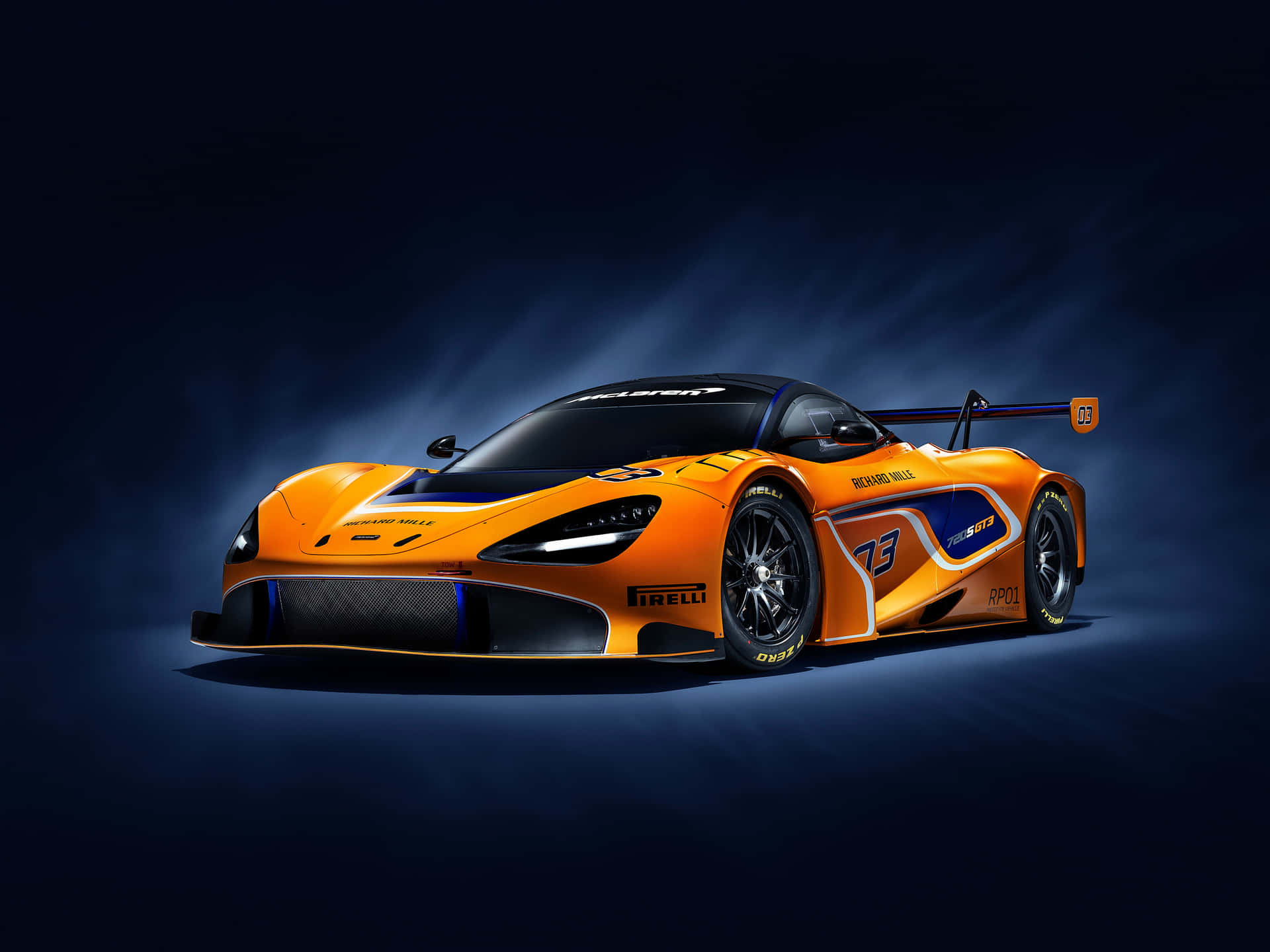 橙色McLaren SRT賽車，帶有藍色點綴和73號，在工作室燈光下。