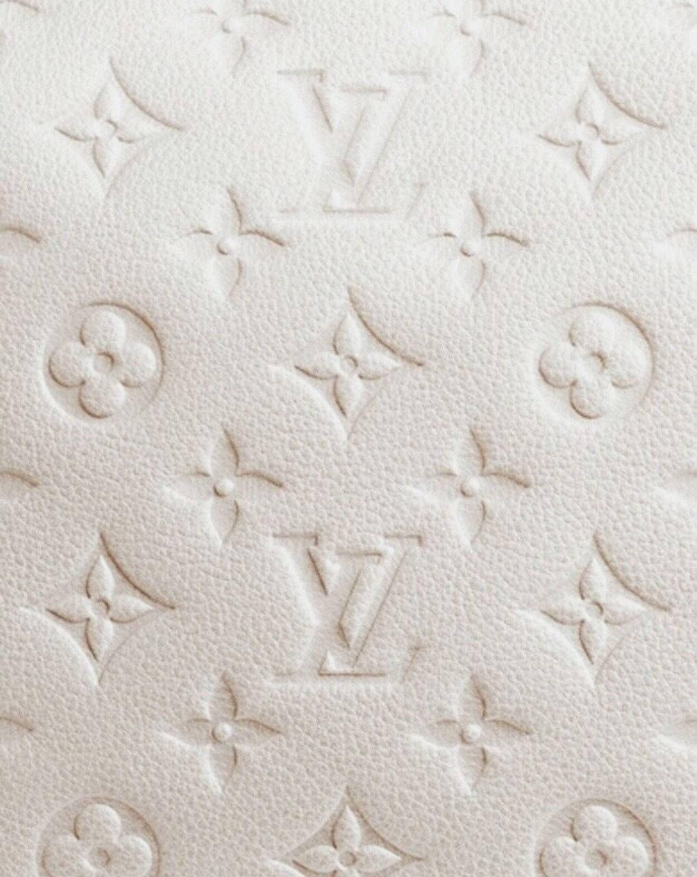 奶油色皮革，帶有壓花 Louis Vuitton 標誌和花卉設計。