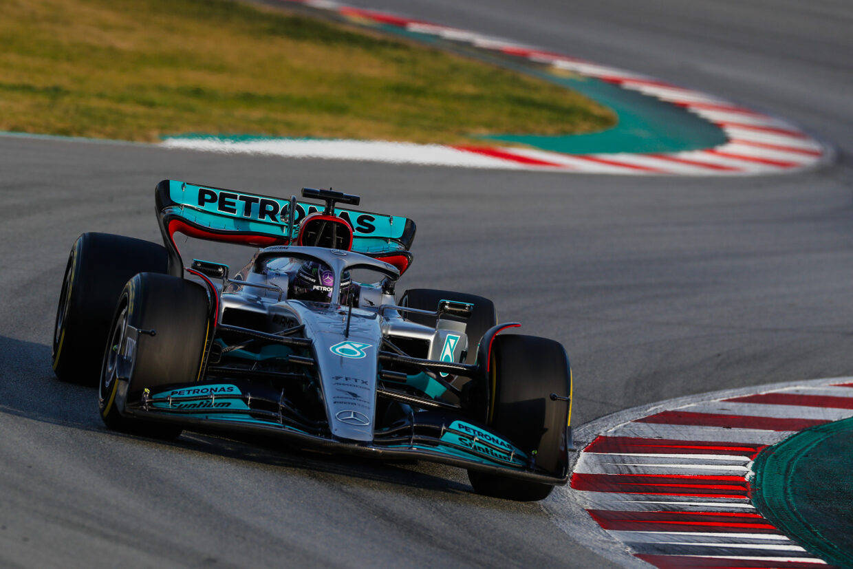 Mercedes F1賽車在日落時分的賽道上奔馳。