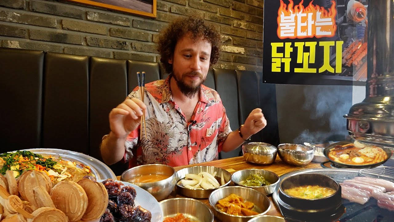 男人吃韓國燒烤，熱鍋和配菜冒著蒸氣。