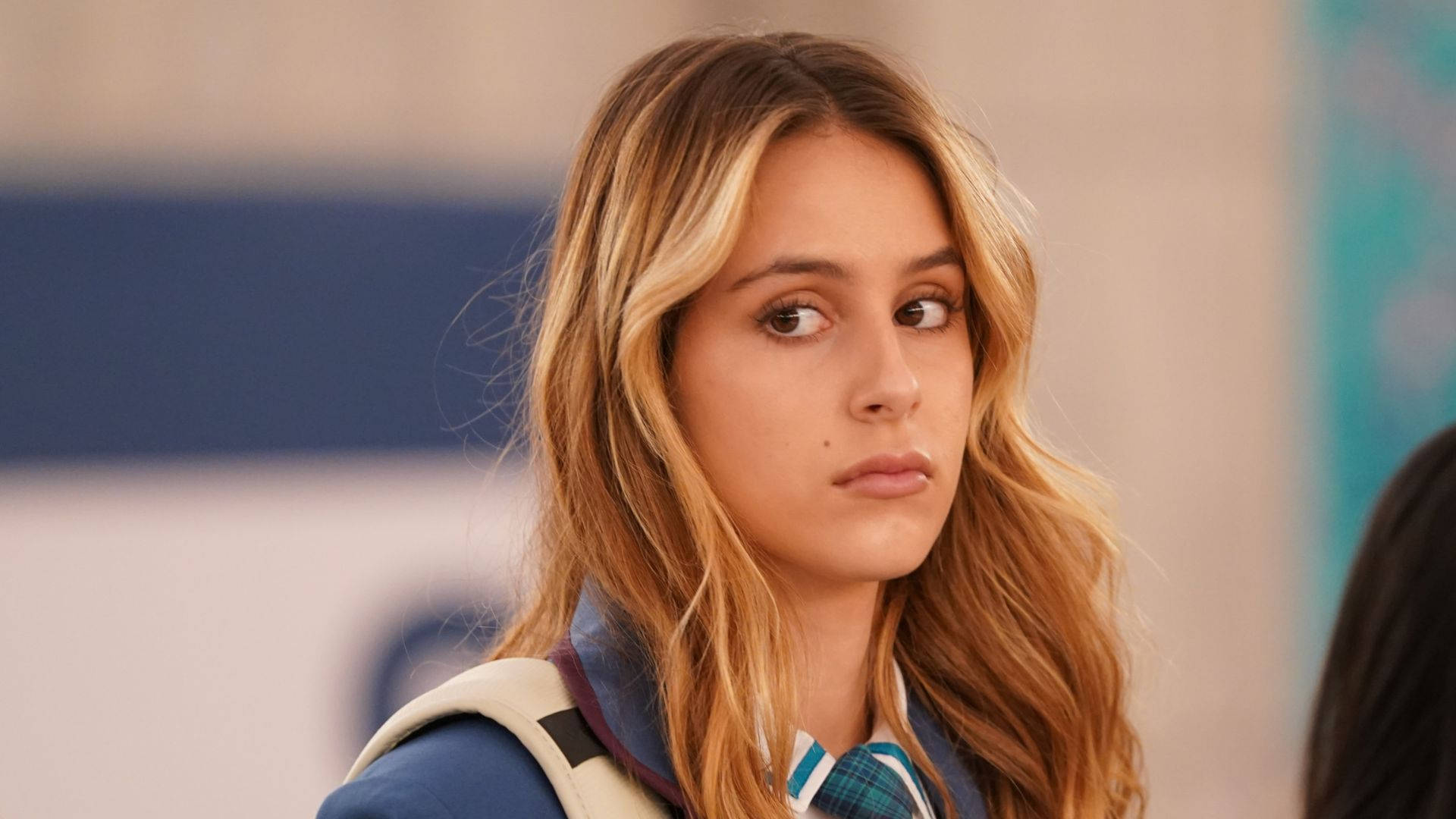 穿著校服揹著背包的年輕女孩若有所思地望向遠方