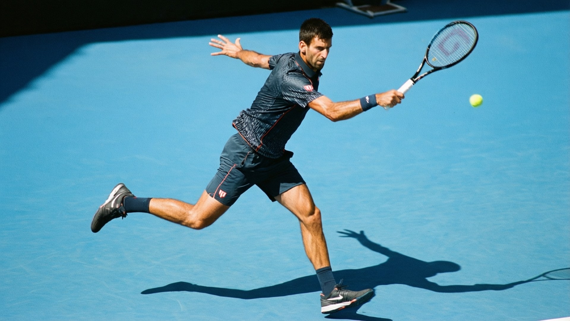 網球運動員在藍色球場上撲出擊球，強烈的陽光投射出陰影。