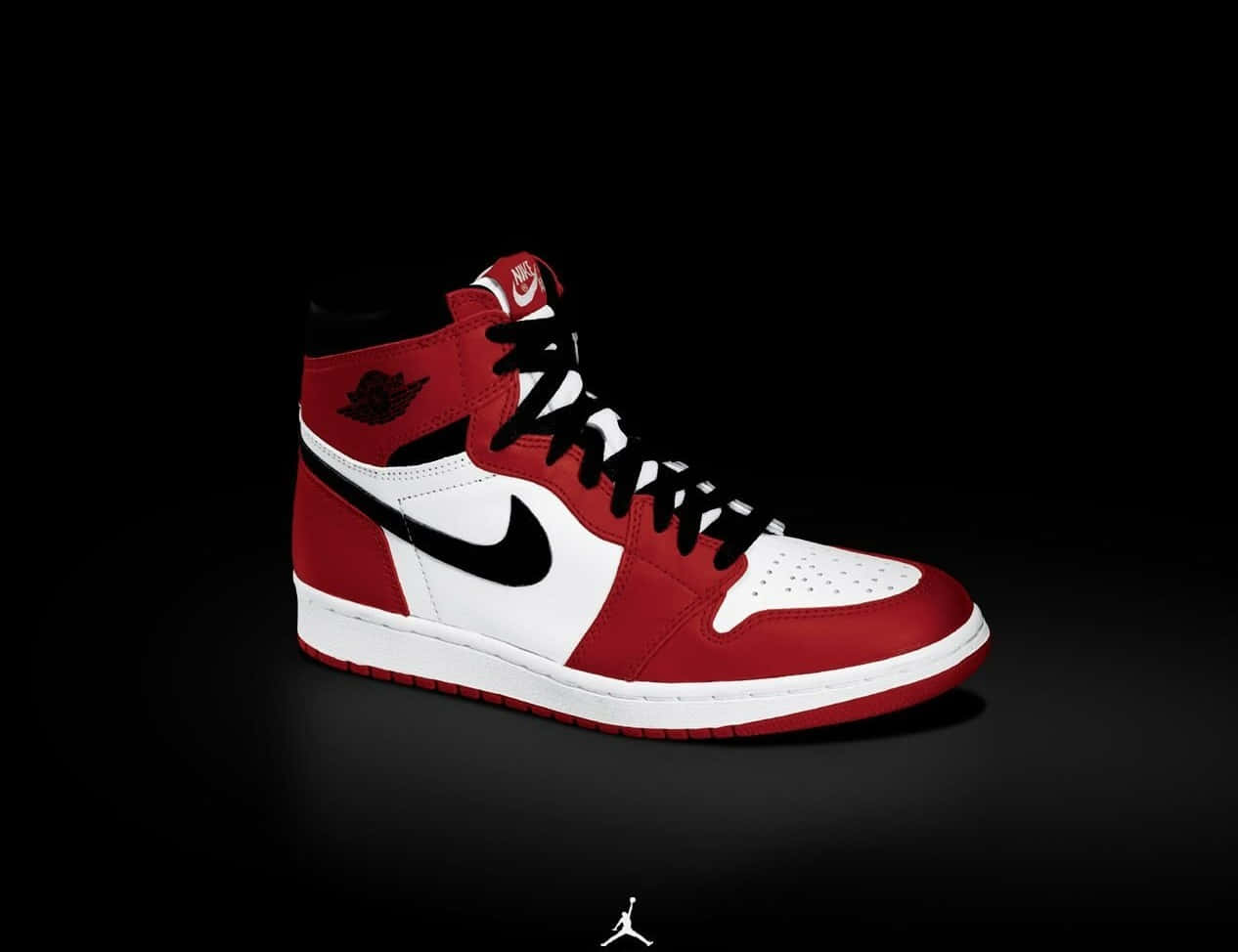 躍入傳奇 Nike Air Jordan 壁紙 — 一對紅白黑高筒運動鞋，帶有黑色剔號和翅膀標誌，居中放在純黑色背景上。