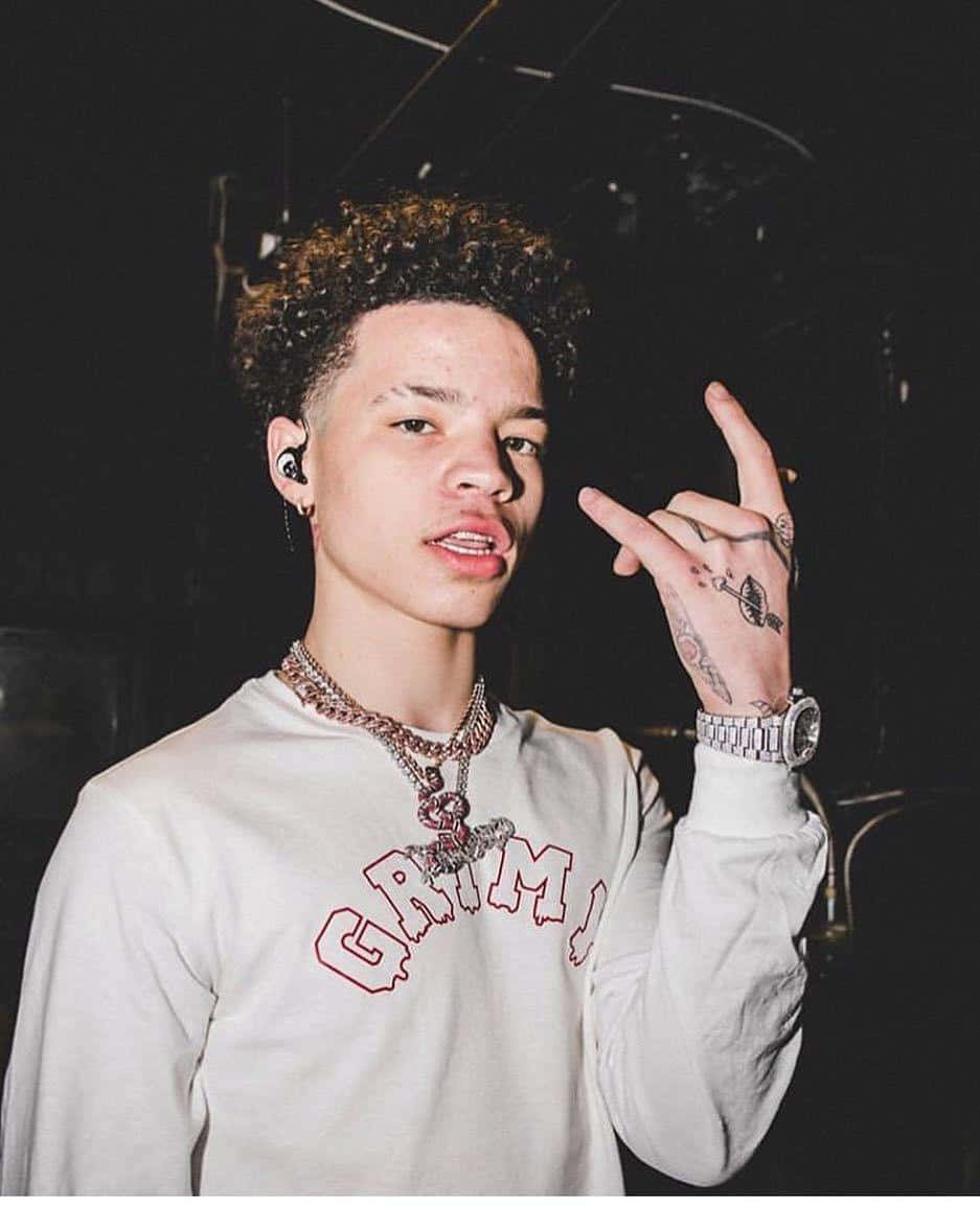 有紋身和鏈條的年輕男子在音樂會上做出手勢
