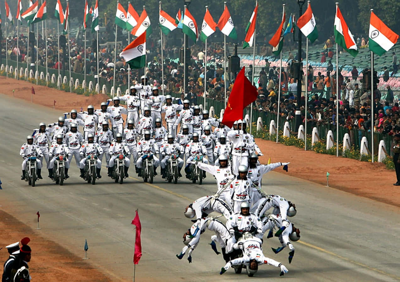 Republic Day 桌布 壁紙 — 身穿白色制服的電單車車手在背景中飄揚的印度國旗襯托下，表演同步特技隊形。