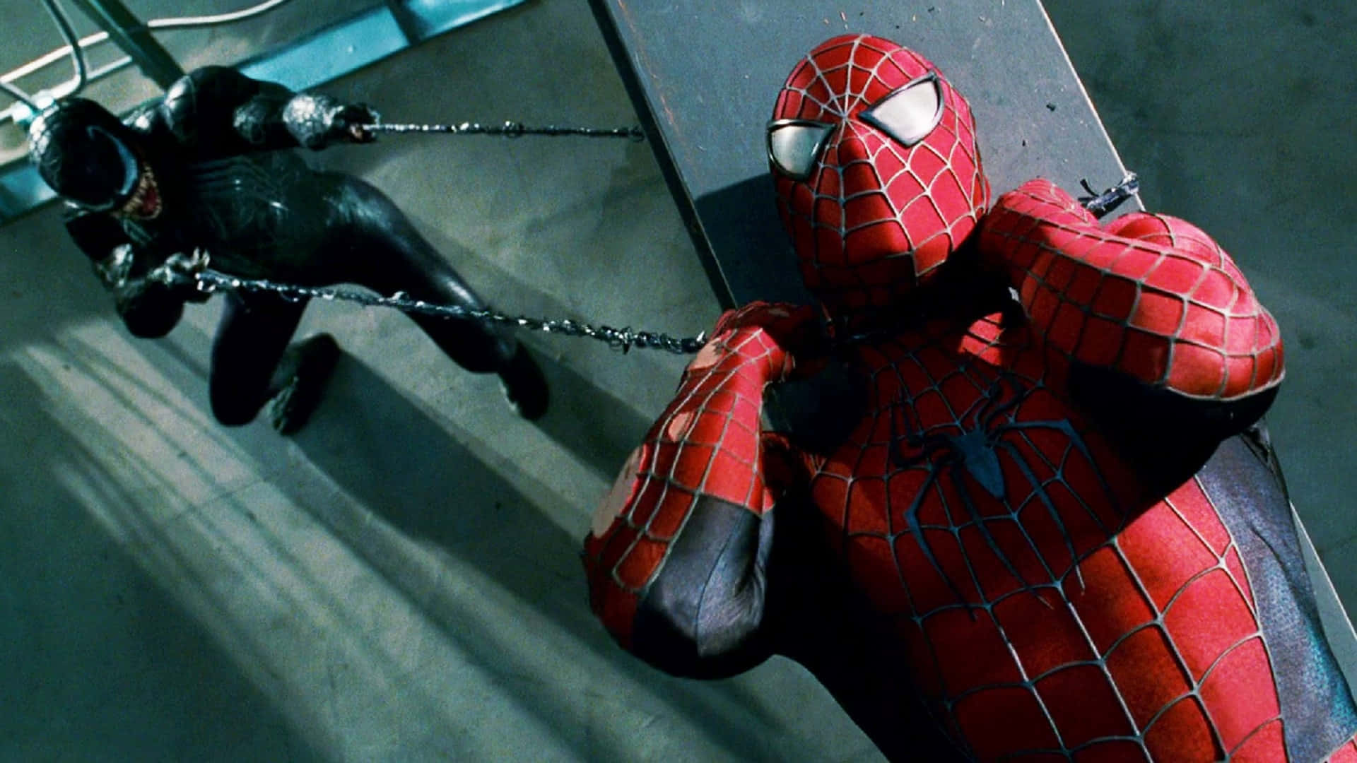 Spider Man 3 桌布 壁紙 — 身穿紅色戰衣的蜘蛛俠在金屬屋頂上，在戲劇性的燈光下與身穿黑色戰衣的毒魔搏鬥。