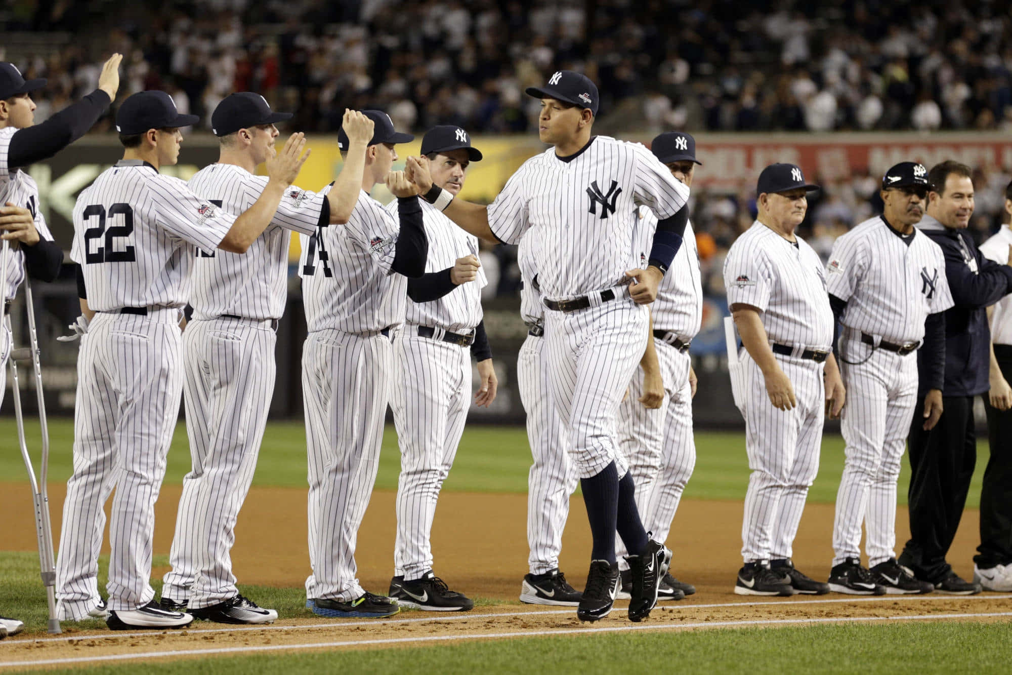 Yankees 桌布 壁紙 — 身穿細條紋球衣的紐約洋基棒球運動員在夜間燈光球場上擊掌慶祝。