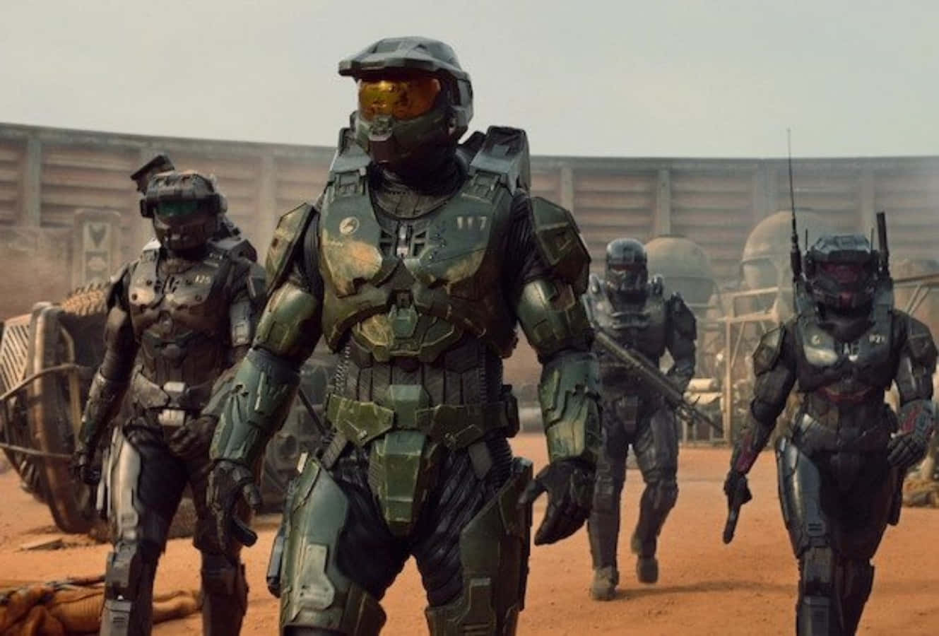 Halo Spartans 桌布 壁紙 — 身穿綠色裝甲服的士兵在朦朧的天空下，穿越塵土飛揚的外星戰場。