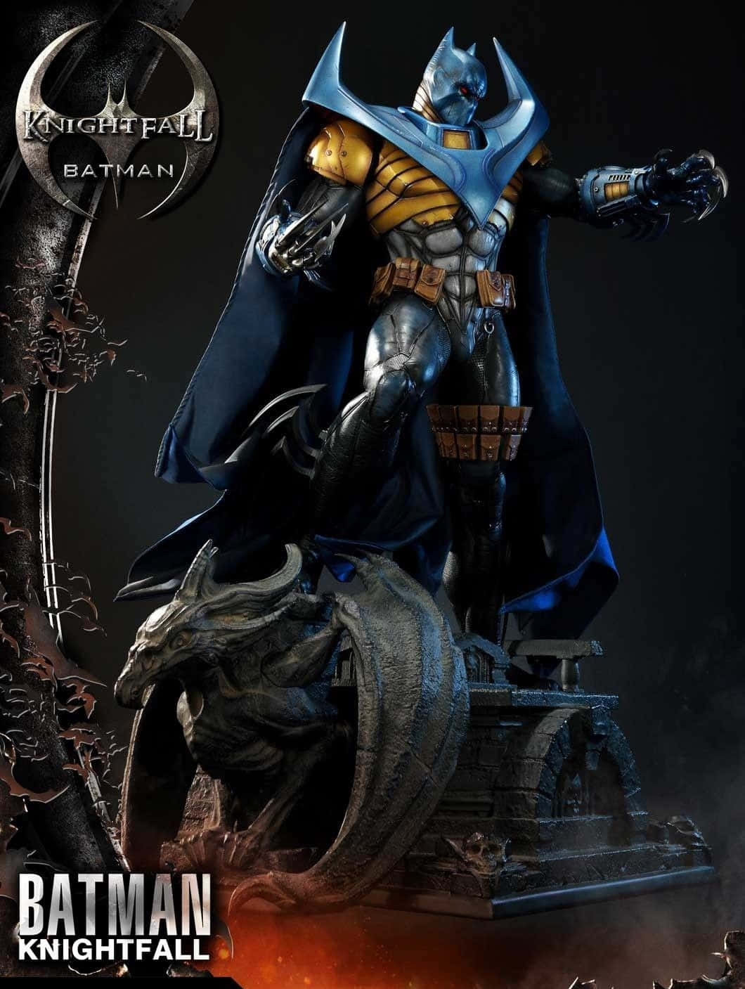 Batman Knightfall 桌布 壁紙 — 身穿藍金裝甲的蝙蝠俠 Knightfall 雕像，威風凜凜地站在龍雕像之上，背景昏暗。