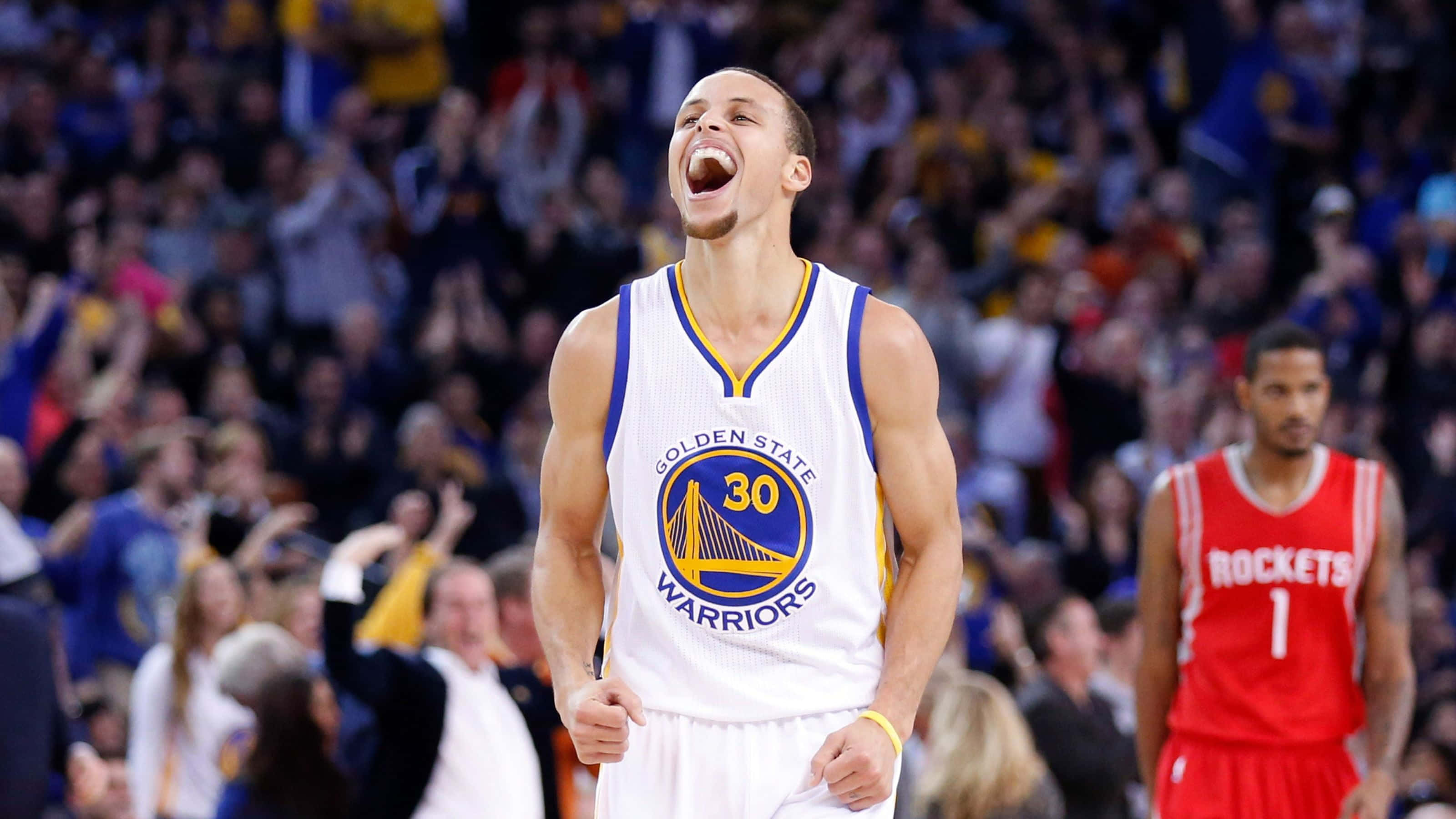 steph curry 桌布 壁紙 — 身穿金州勇士隊球衣的籃球運動員在比賽中張大嘴巴慶祝，背景有觀眾。