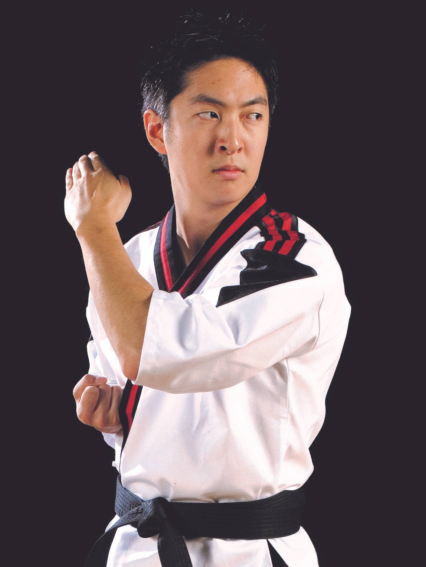 身穿白色道服、繫著黑帶的武術家擺出姿勢。