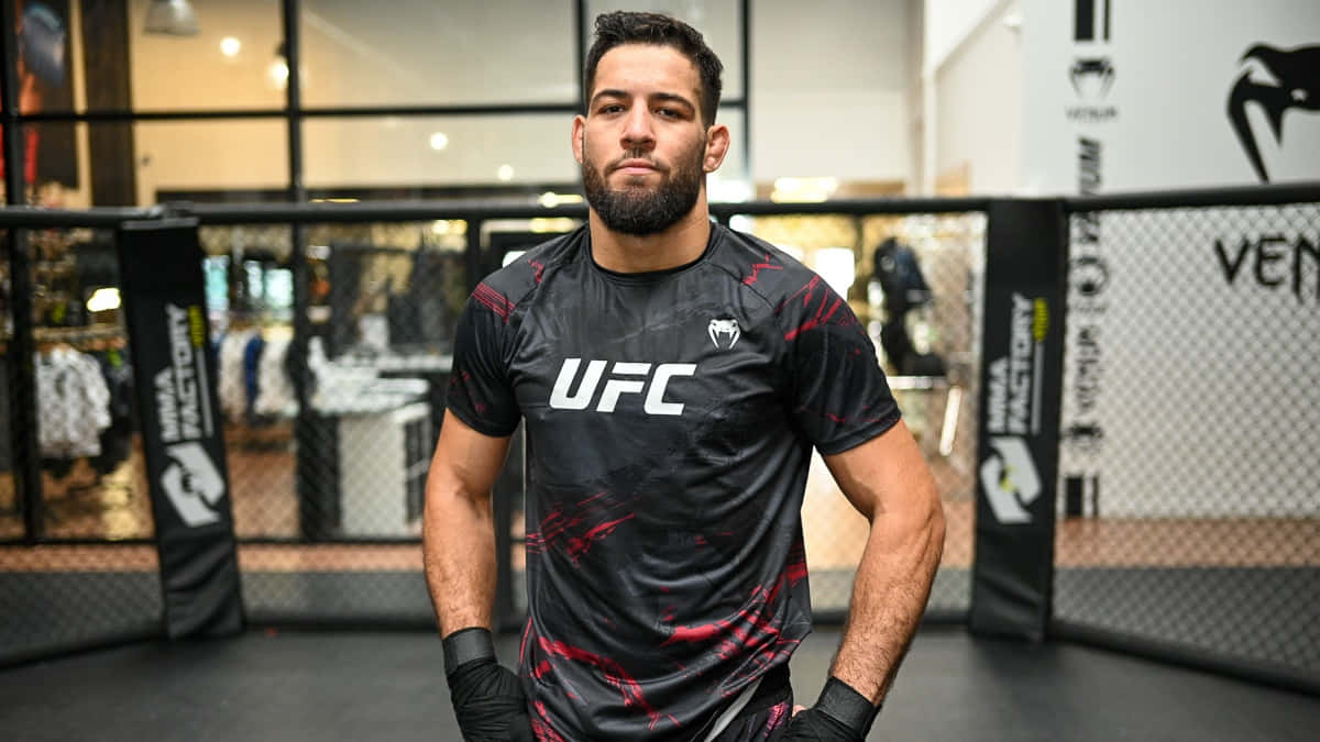 一位身穿UFC裝備的男性MMA拳手站在八角籠內。
