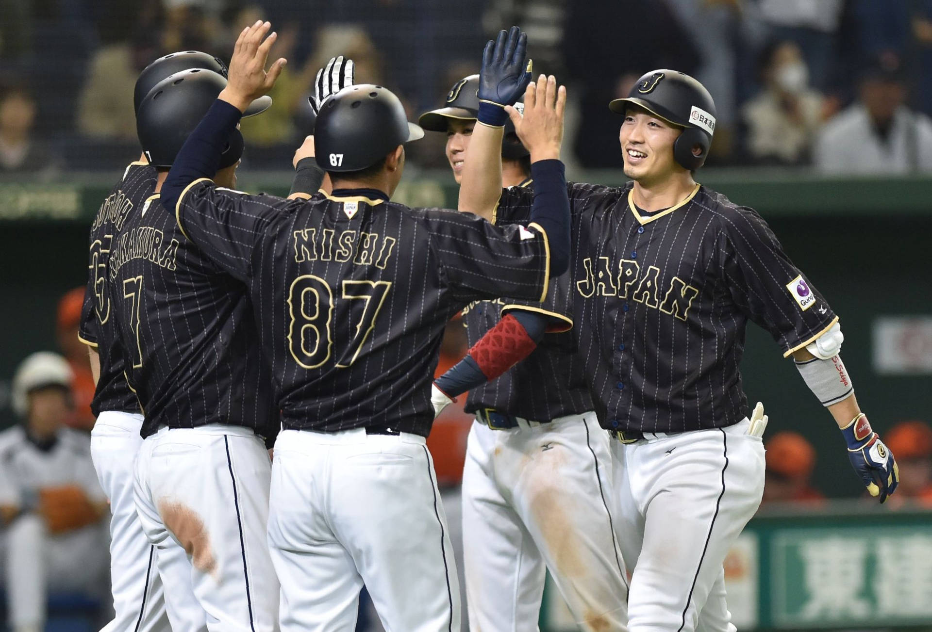 日本棒球隊在夜間於球場慶祝比賽