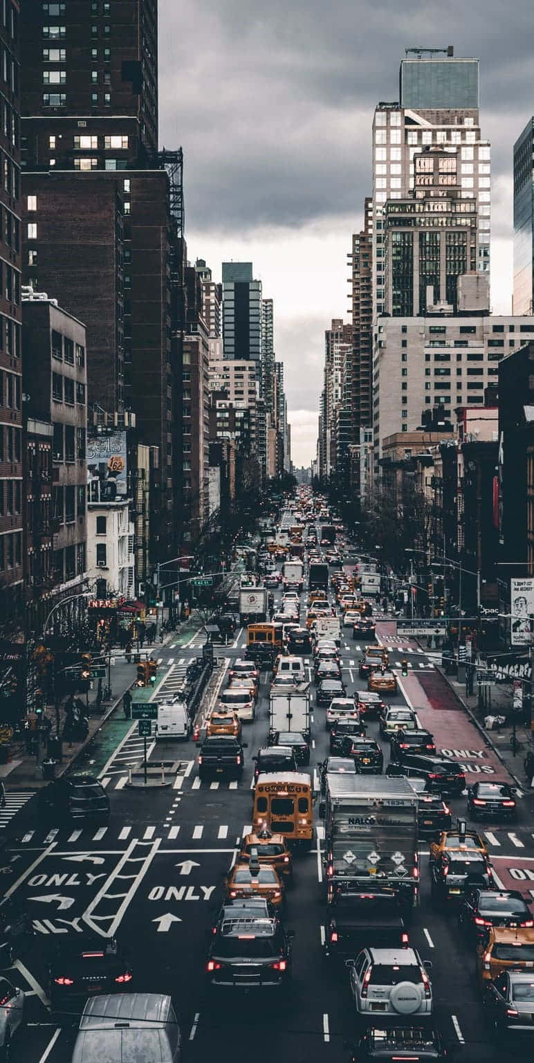 繁忙的城市街道，在多雲的天空下，充滿汽車和高樓大廈。