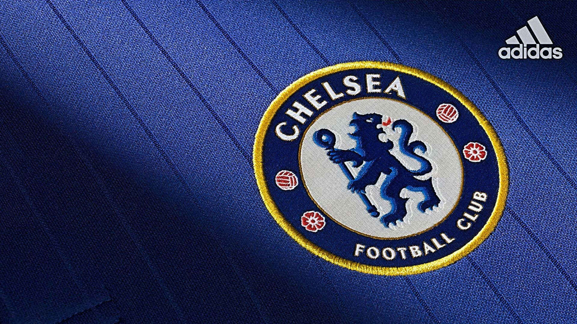 Chelsea 桌布 壁紙 — 車路士足球會會徽近距離特寫，繡於帶有Adidas標誌的質感皇家藍條紋球衣上。