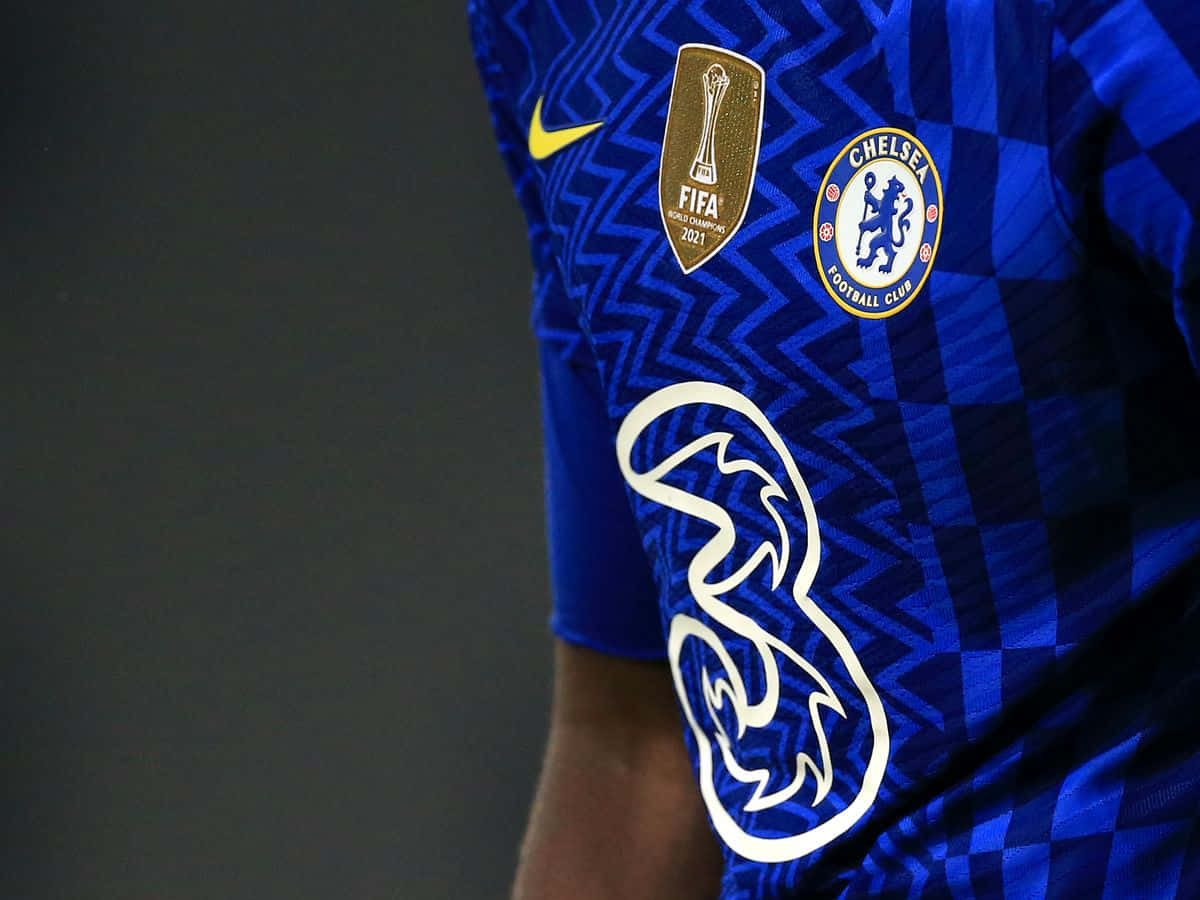 Chelsea 桌布 壁紙 — 車路士足球會球衣特寫，帶有藍色幾何圖案和2021年國際足協世界冠軍球會盃臂章。